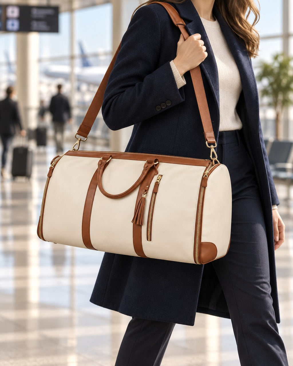The Folvia Bag in Sand carried on the shoulder at the airport